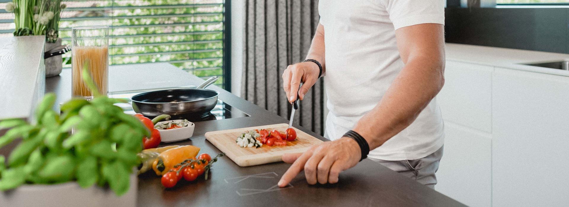 Mann in Küche beim Kochen mit Touch Surface auf Arbeitsfläche