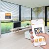 Hand mit Smartphone (Smart Home App) Hintergrund Fensterfront im Wohnzimmer