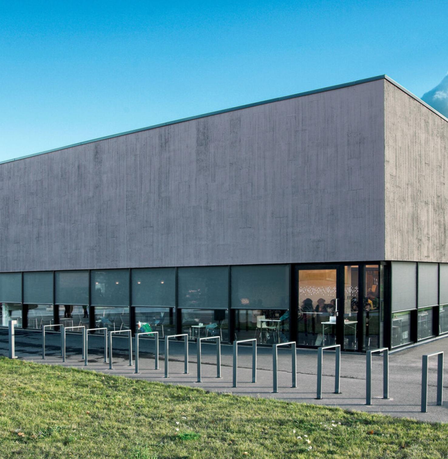 Moderner, zweigeschossiger Baukörper mit umlaufender Fensterfront und Textilscreens