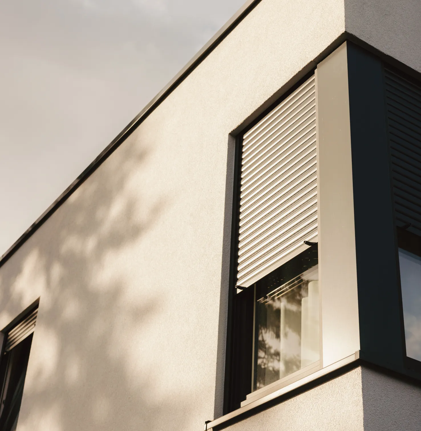 Haus mit ROMA Rollladen bei Sonnenschein