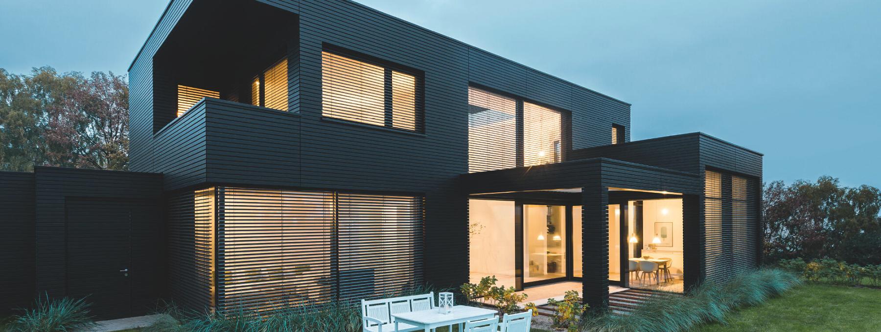 Modernes Haus bei Dämmerung mit Innenbeleuchtung mit Comfort und Design Lamellen