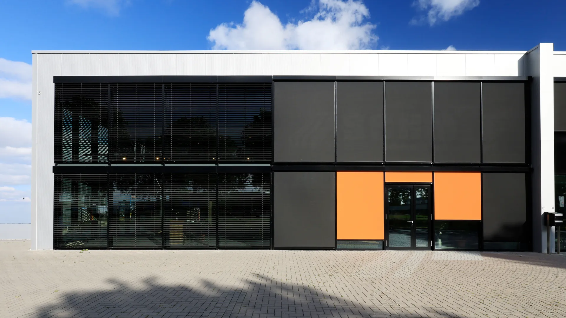 Gewerbebau mit ROMA F50 Systemen Senkrechtmarkisen und Außenjalousien