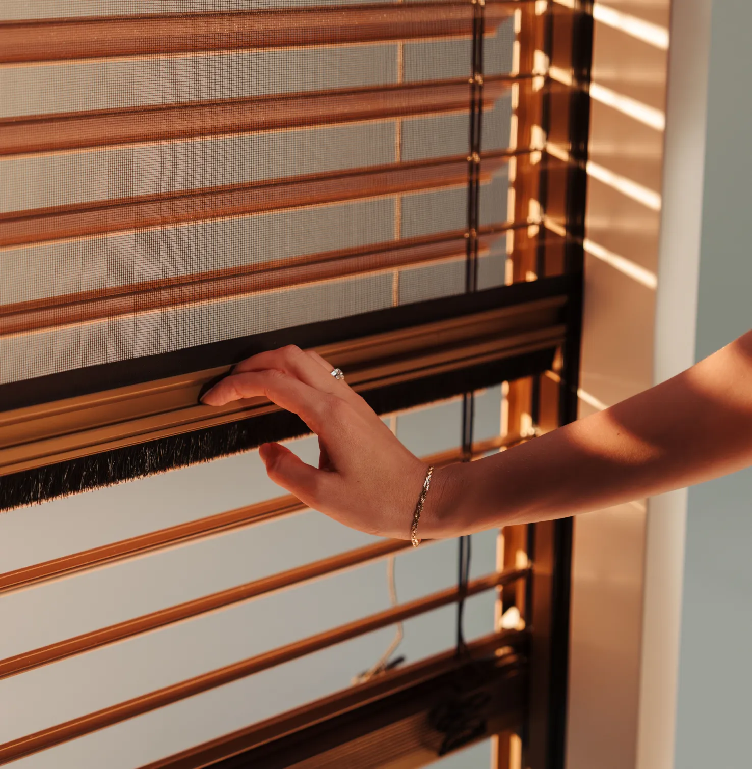 Hand an Insektenschutzgitter vor Raffstoren