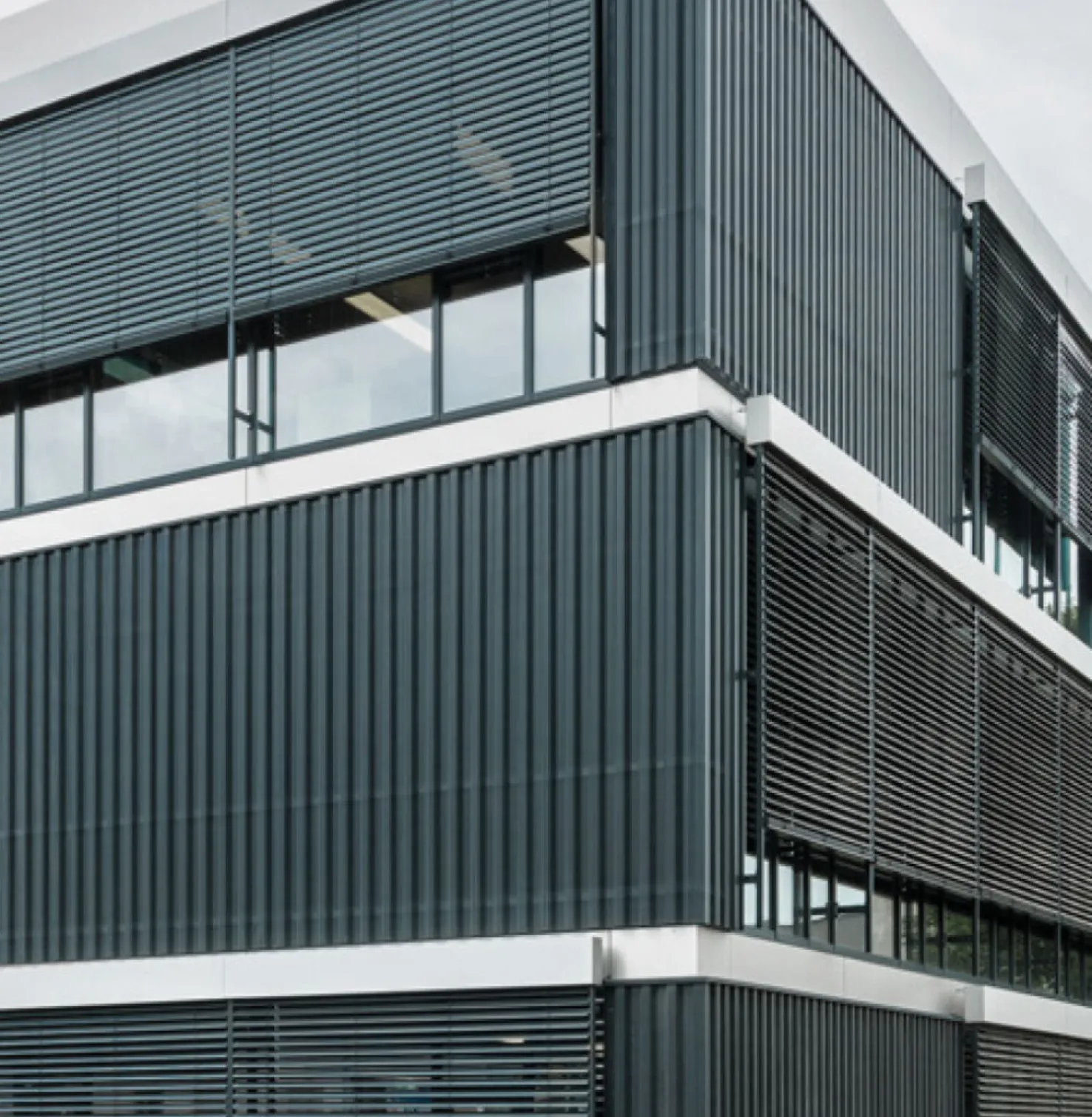 Modernes Bürogebäude bei Tag mit Fassadenraffstoren